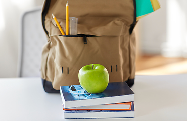 Image showing school backpack with books and apple on table