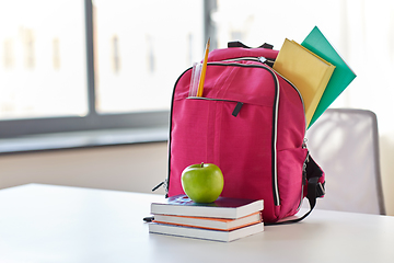 Image showing pink backpack, apple and school supplies on table