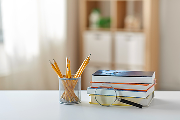 Image showing book with magnifier and pencil on table at home