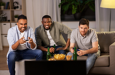 Image showing happy friends playing video games at home at night