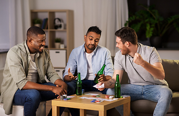 Image showing male friends playing cards at home at night