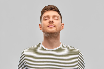 Image showing happy young man in striped t-shirt breathing