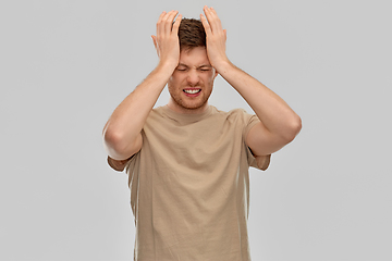 Image showing unhappy man suffering from headache