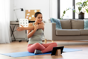 Image showing happy woman with tablet pc doing sports at home