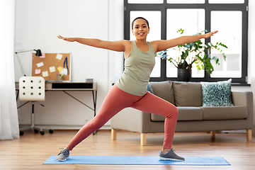 Image showing african woman doing yoga warrior pose at home