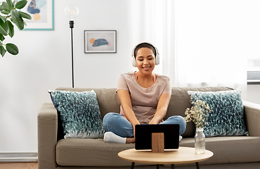 Image showing woman with headphones and tablet computer at home