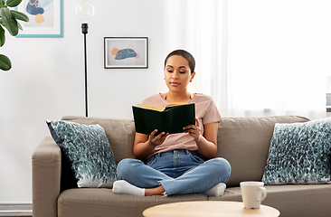 Image showing african american woman reading book at home