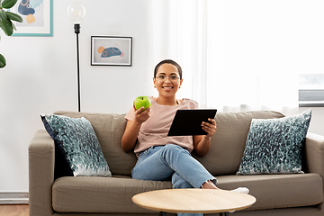 Image showing african woman with tablet pc and apple at home