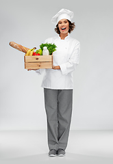 Image showing happy smiling female chef with food in wooden box