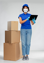 Image showing delivery woman in mask with boxes and tablet pc