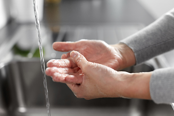 Image showing woman washing hands with soap in kitchen