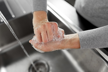 Image showing woman washing hands with soap in kitchen