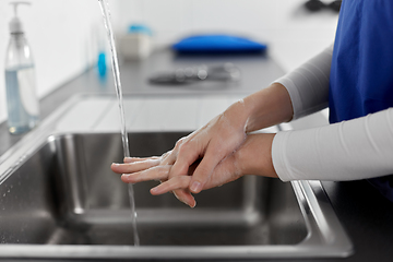 Image showing doctor or nurse washing hands with liquid soap