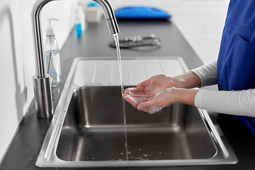 Image showing doctor or nurse washing hands with liquid soap