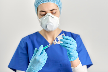 Image showing doctor in face mask with syringe and medicine