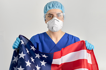 Image showing doctor in goggles and mask holding flag of america