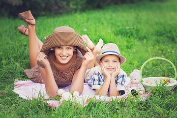 Image showing Little boy and teen age girl having picnic outdoors