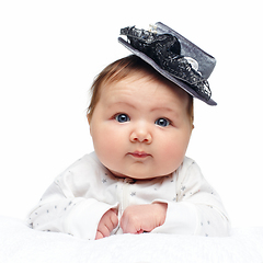 Image showing beautiful baby girl in fancy hat on white blanket