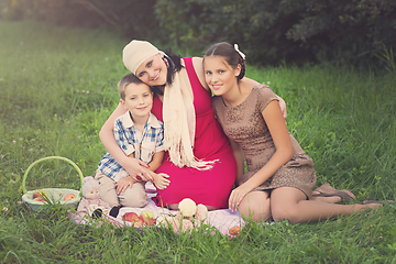 Image showing mother with two kids having picnic outdoors