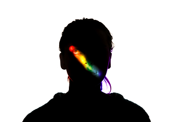 Image showing Dramatic portrait of a girl in the dark on white studio background with rainbow colored line