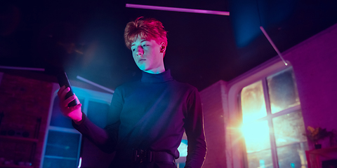 Image showing Cinematic portrait of handsome young man in neon lighted interior