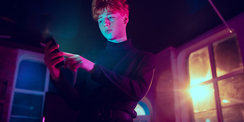 Image showing Cinematic portrait of handsome young man in neon lighted interior