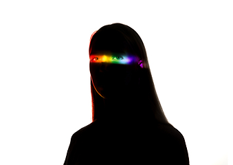 Image showing Dramatic portrait of a girl in the dark on white studio background with rainbow colored line