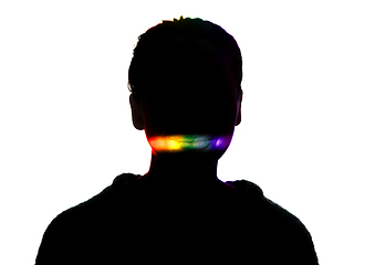 Image showing Dramatic portrait of a girl in the dark on white studio background with rainbow colored line