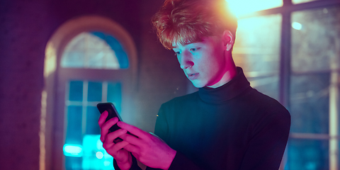 Image showing Cinematic portrait of handsome young man in neon lighted interior