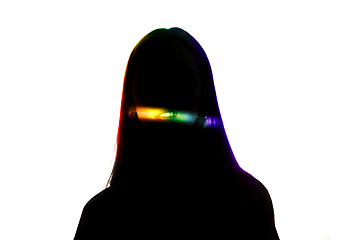 Image showing Dramatic portrait of a girl in the dark on white studio background with rainbow colored line