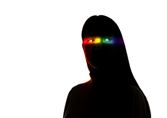 Image showing Dramatic portrait of a girl in the dark on white studio background with rainbow colored line