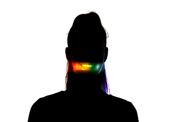 Image showing Dramatic portrait of a girl in the dark on white studio background with rainbow colored line