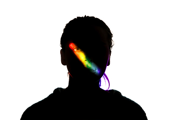 Image showing Dramatic portrait of a girl in the dark on white studio background with rainbow colored line