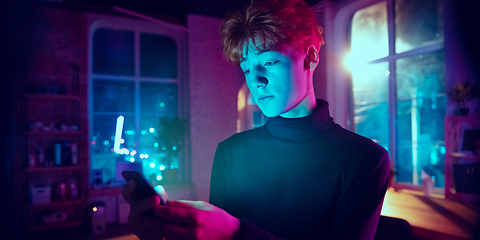 Image showing Cinematic portrait of handsome young man in neon lighted interior