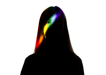 Image showing Dramatic portrait of a girl in the dark on white studio background with rainbow colored line