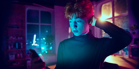 Image showing Cinematic portrait of handsome young man in neon lighted interior