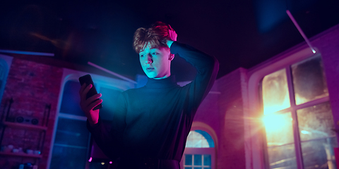 Image showing Cinematic portrait of handsome young man in neon lighted interior