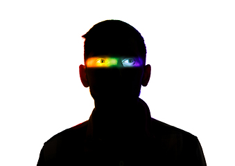 Image showing Dramatic portrait of a man in the dark on white studio background with rainbow colored line