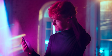 Image showing Cinematic portrait of handsome young man in neon lighted interior