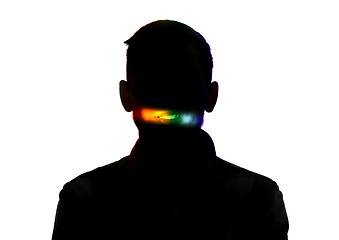 Image showing Dramatic portrait of a man in the dark on white studio background with rainbow colored line