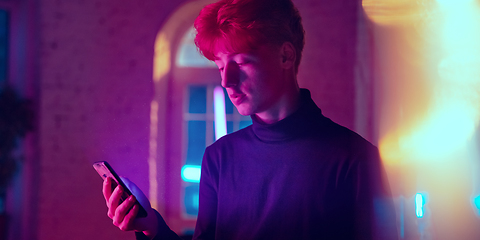 Image showing Cinematic portrait of handsome young man in neon lighted interior