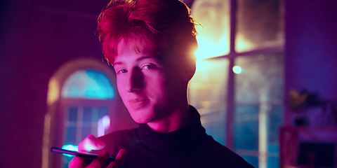 Image showing Cinematic portrait of handsome young man in neon lighted interior