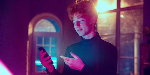 Image showing Cinematic portrait of handsome young man in neon lighted interior