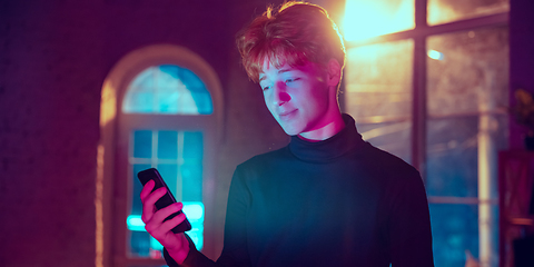 Image showing Cinematic portrait of handsome young man in neon lighted interior