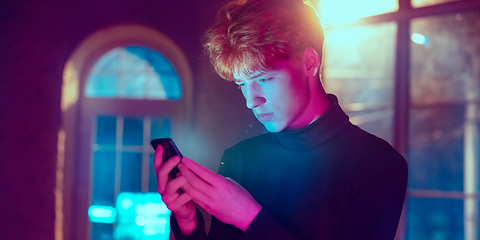 Image showing Cinematic portrait of handsome young man in neon lighted interior