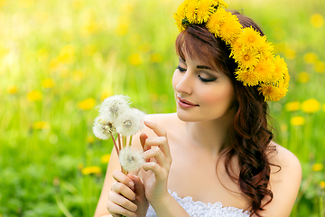 Image showing beautiful girl with dandelion flowers in green field