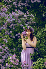 Image showing beautiful girl in purple dress with lilac flowers