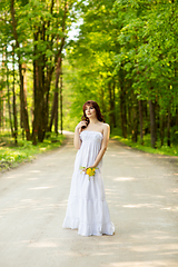 Image showing beautiful girl with dandelion flowers on forest road