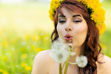 Image showing beautiful girl with dandelion flowers in green field