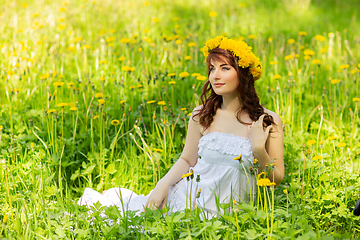 Image showing beautiful girl with dandelion flowers in green field